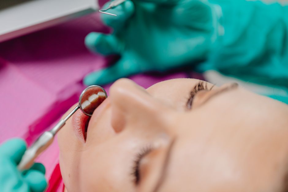 Patient undergoing a dental examination, focusing on tools and technique.