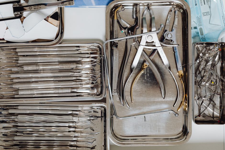 Sterile dental tools arranged on metal trays for dental procedures.