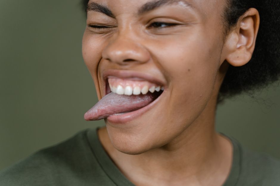 Close-up of a cheerful woman with her tongue out, winking playfully.