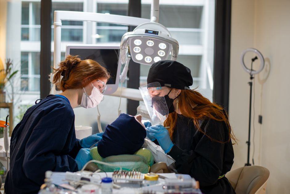Dentists performing a procedure in a modern clinic with advanced equipment.