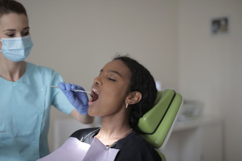 A dentist performs a dental examination on a patient in a clinic.