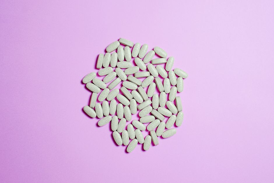 A cluster of white pills on a purple surface, highlighting pharmaceutical themes.