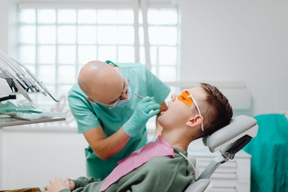 A dentist conducts a dental check-up on a patient in a modern clinic setting.
