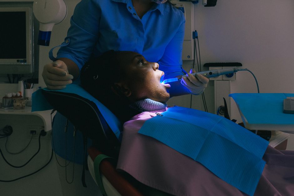 Dentist uses modern equipment for dental treatment on a patient in a clinic.