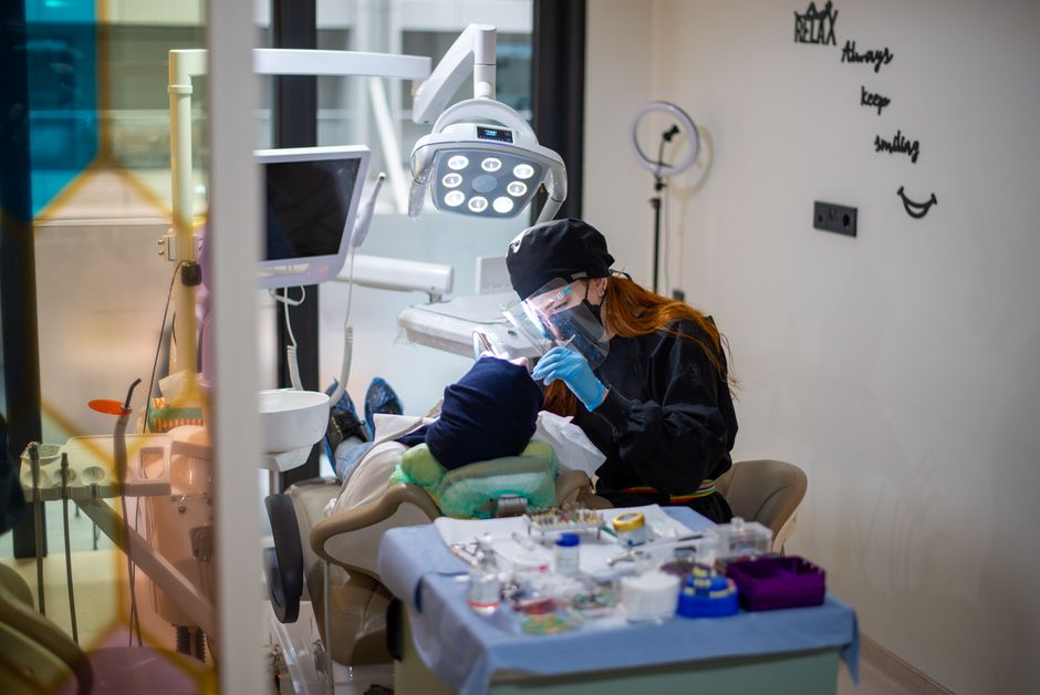 Dentist performing a dental checkup with advanced equipment in a contemporary clinic.