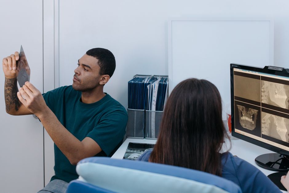 Two dental professionals reviewing X-rays in a modern clinic setting.