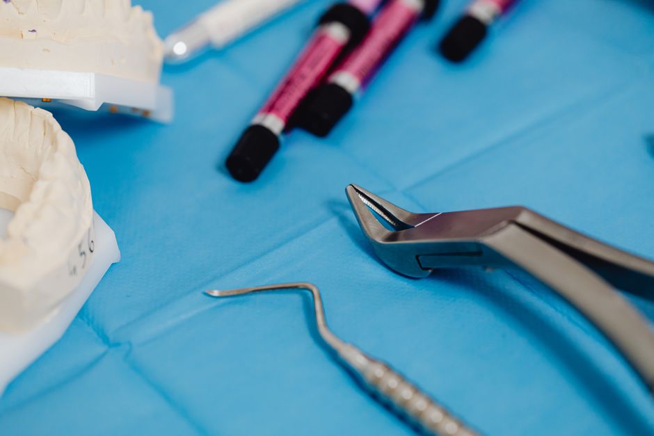 Detailed view of dental equipment and models on a sterile blue background in a healthcare setting.