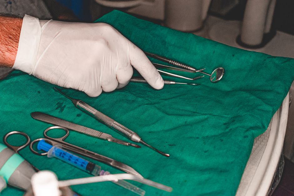 Close-up of dental tools on a green cloth prepared for a medical procedure.