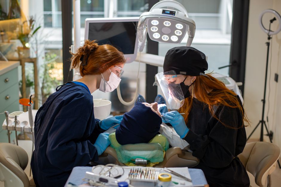 Two dentists performing a dental procedure with advanced equipment in a modern clinic.