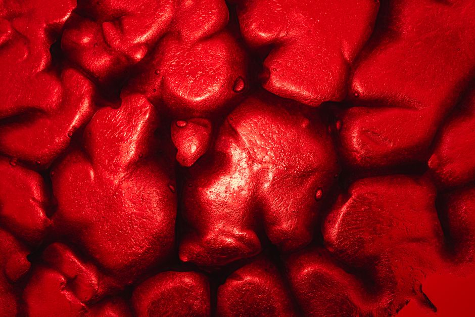 A close-up of a vibrant red abstract texture resembling organic forms, perfect for artistic backgrounds.