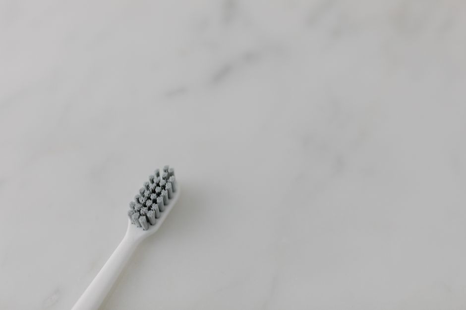 A single toothbrush on a marble background emphasizing clean oral hygiene in a minimalist style.
