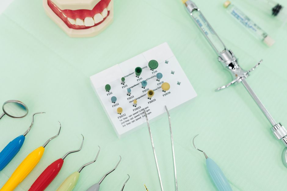 A close-up of dental tools and a jaw model on a green background, ideal for dentistry themes.