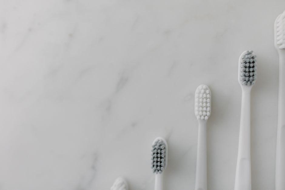 Elegant minimalist display of white toothbrushes against a marble surface, ideal for visual fresh style.