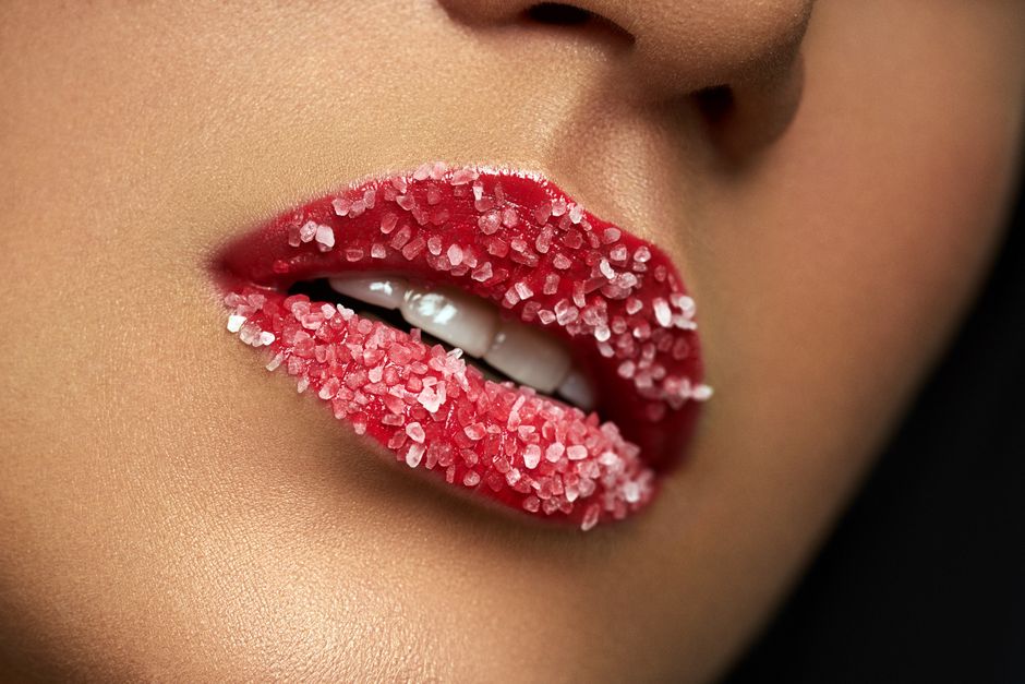 Stunning close-up of red lips adorned with sugar crystals, showcasing beauty and glamour.