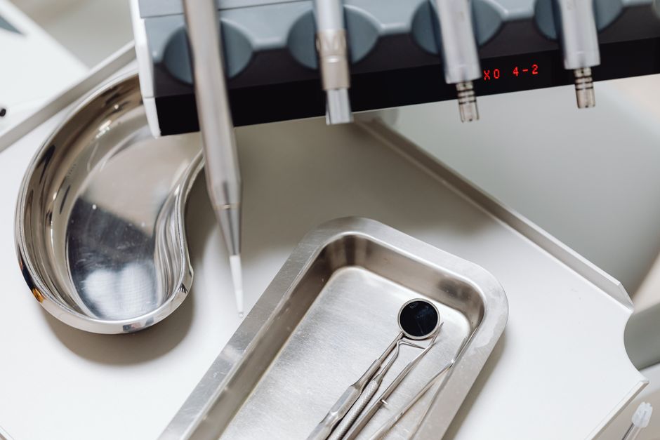 Dental instruments on a silver tray, ideal for illustrating medical and dental themes.