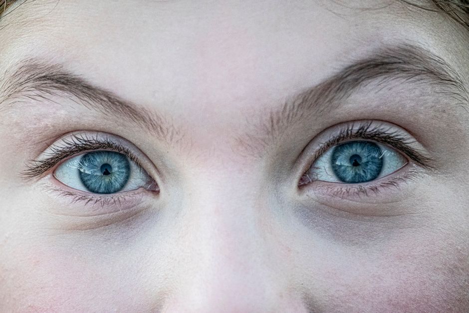 A detailed close-up of captivating blue eyes with natural brows.