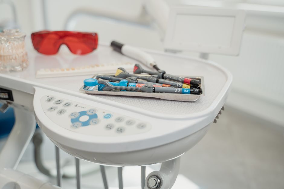 Assortment of dental tools and devices on a clinic table.