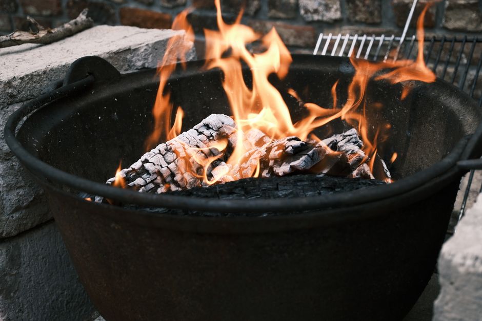 Vibrant flames dance over logs in an outdoor fire pit, creating a warm and inviting atmosphere.