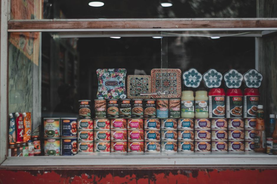 A vibrant selection of canned goods and condiments beautifully arranged in a store window.