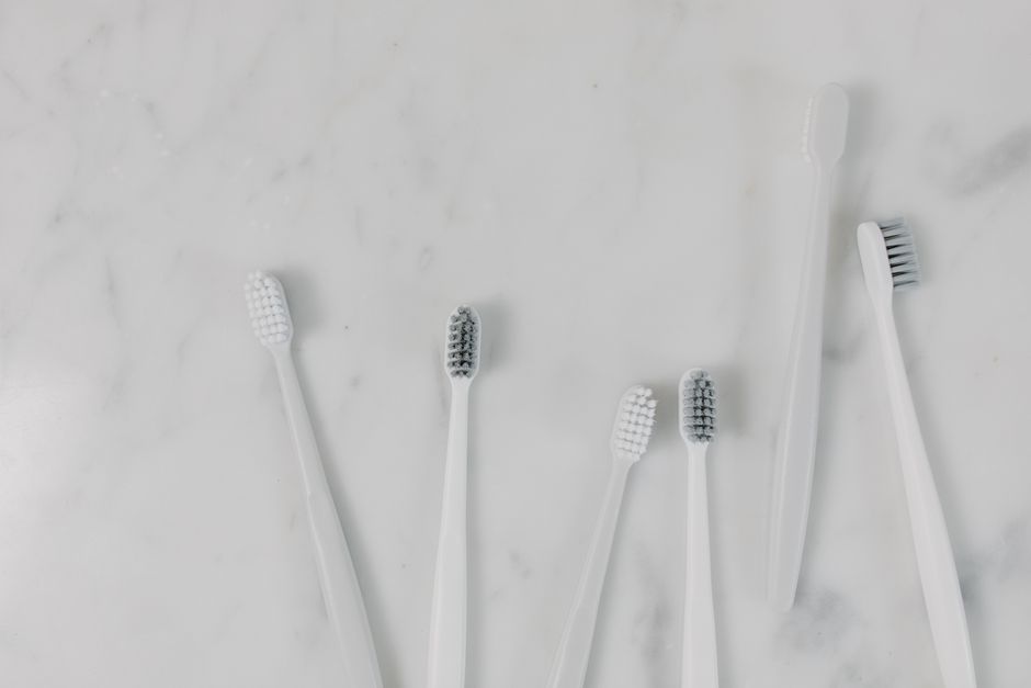 Top view of toothbrushes on a minimalist marble surface, perfect for hygiene themes.