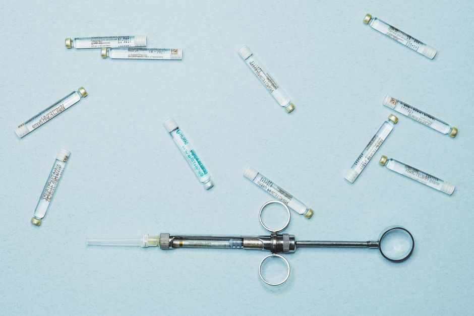 Flat lay of a syringe and vials, ideal for medical themes.