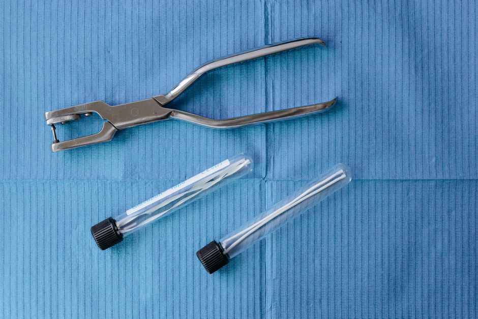 Close-up of dental tools and test tubes on a blue surface, highlighting modern medical equipment.