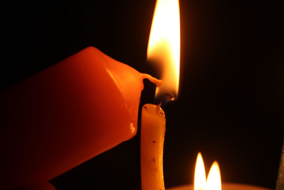 A close-up shot of two candles with flames emitting a warm, soft glow.