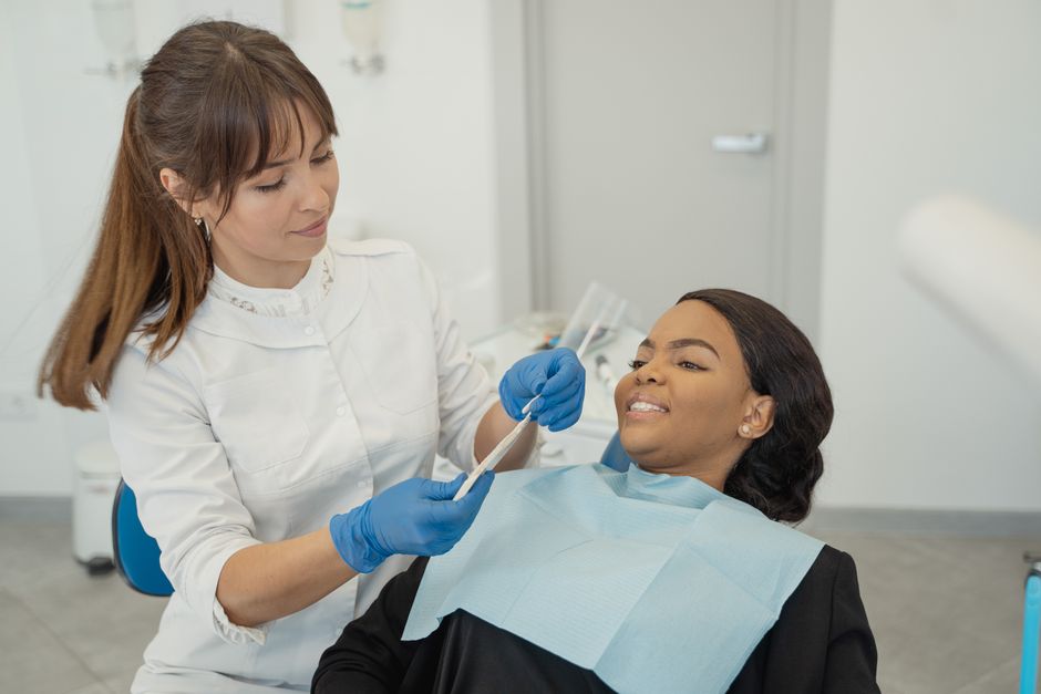 A dentist provides care to a patient during a dental checkup in a clinic setting.